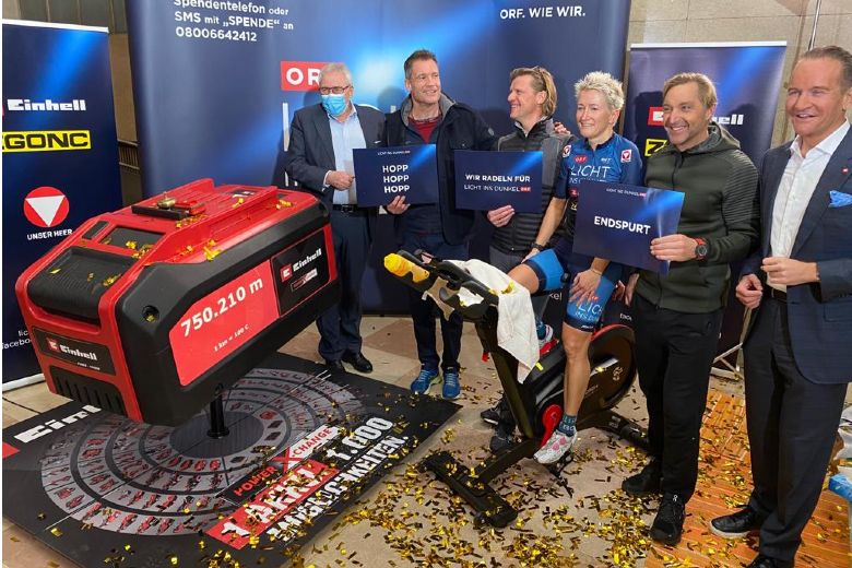 Group with Armin Assinger, Hans Knauß, Gery Seidl, Yvonne Marzinke and Andreas Kroiss supports cycling challenge with oversized battery model.