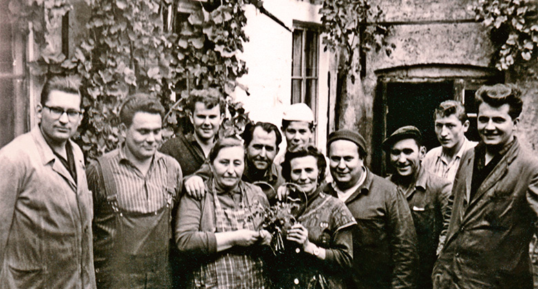 Ein Bild von Menschen, die vor einem Gebäude am Anfang von Einhell stehen.