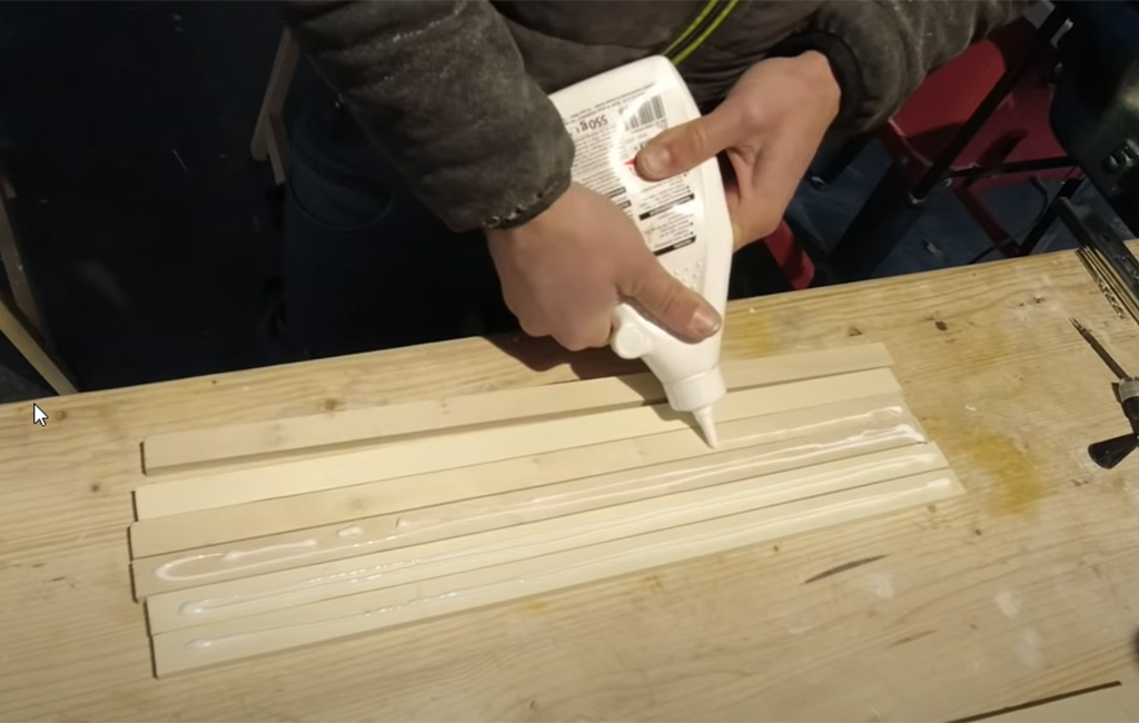 Holzleisten werden nebeneinandergelegt und mit Holzleim bestrichen.