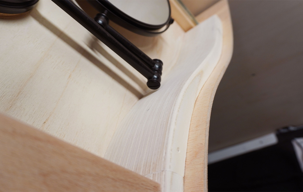 Detailaufnahme der gebogenen Innenseite des Schranks mit montiertem Spiegelarm.