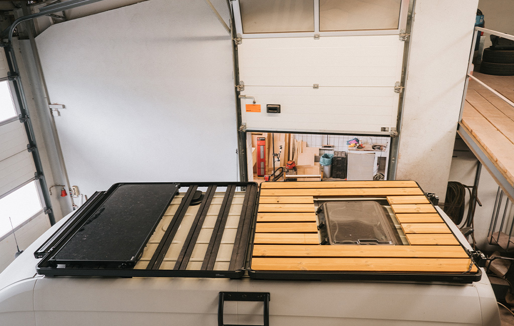 Camper roof with partially installed wooden slats and a roof window in the center.