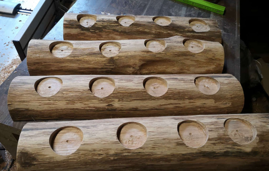 Holzstämme mit gebohrten Löchern, vorbereitet für Teelichthalter.