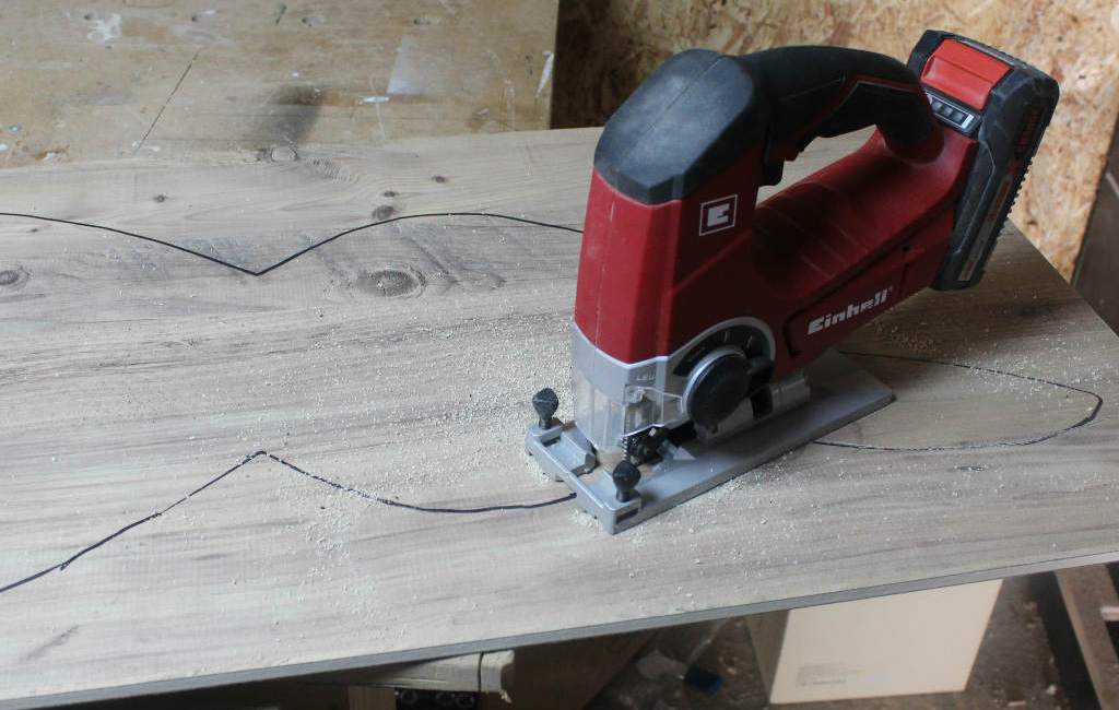 Einhell jigsaw cuts a bunny shape out of a wooden board.