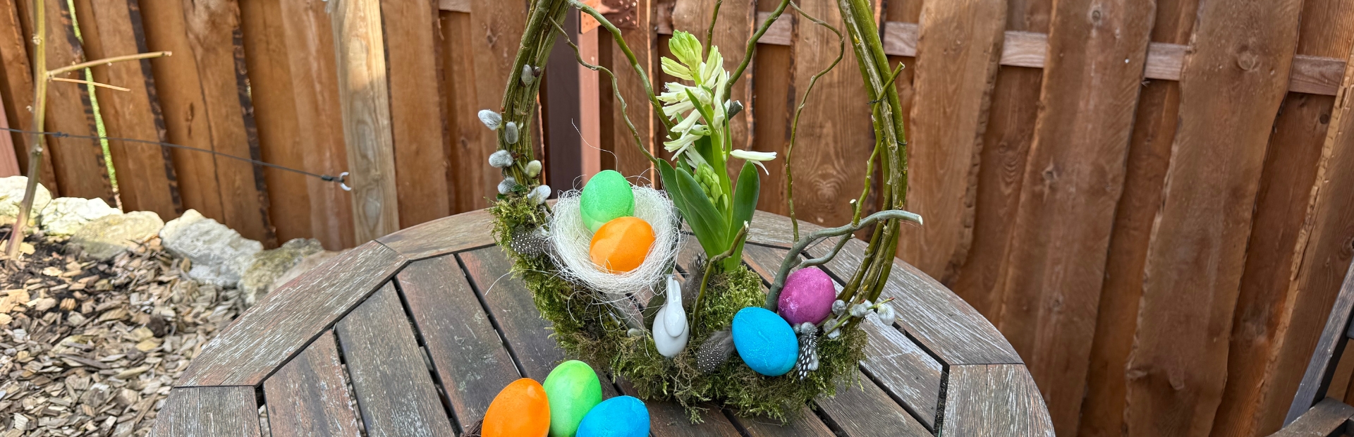 Close-up of the Easter wreath with colorful eggs, moss and flowers.
