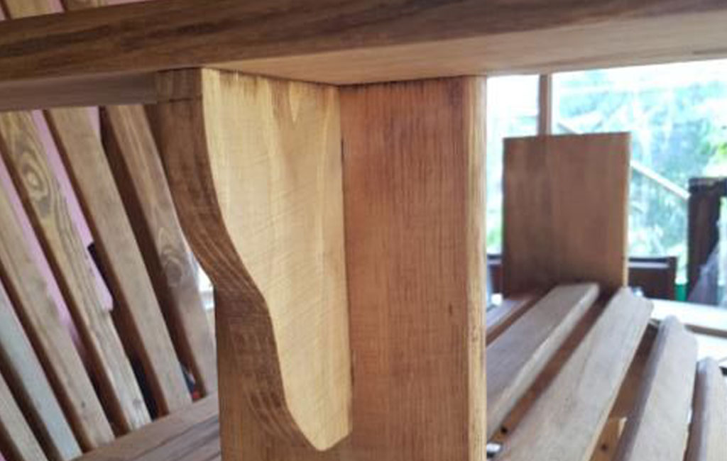 A close-up shows a supporting wooden joint beneath the seat of a garden chair.