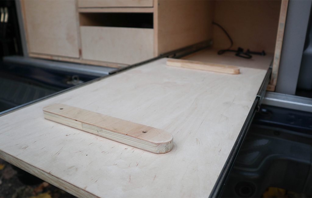 Wooden drawer with simple guide rail and two wooden strips pulled out from a van.