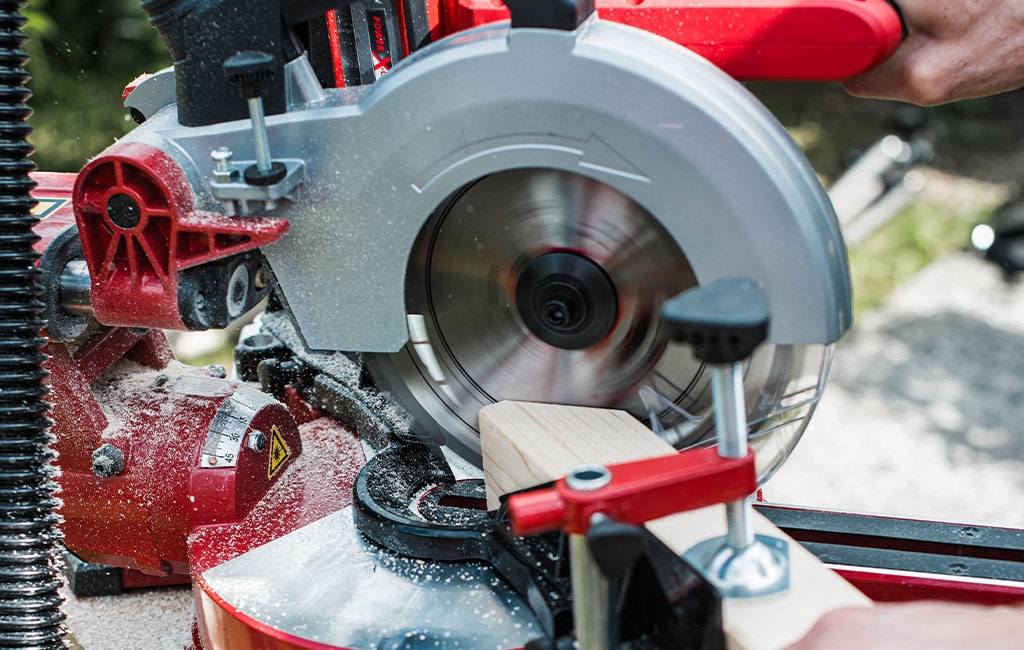 A piece of wood is being cut with a running Einhell sliding mitre saw.