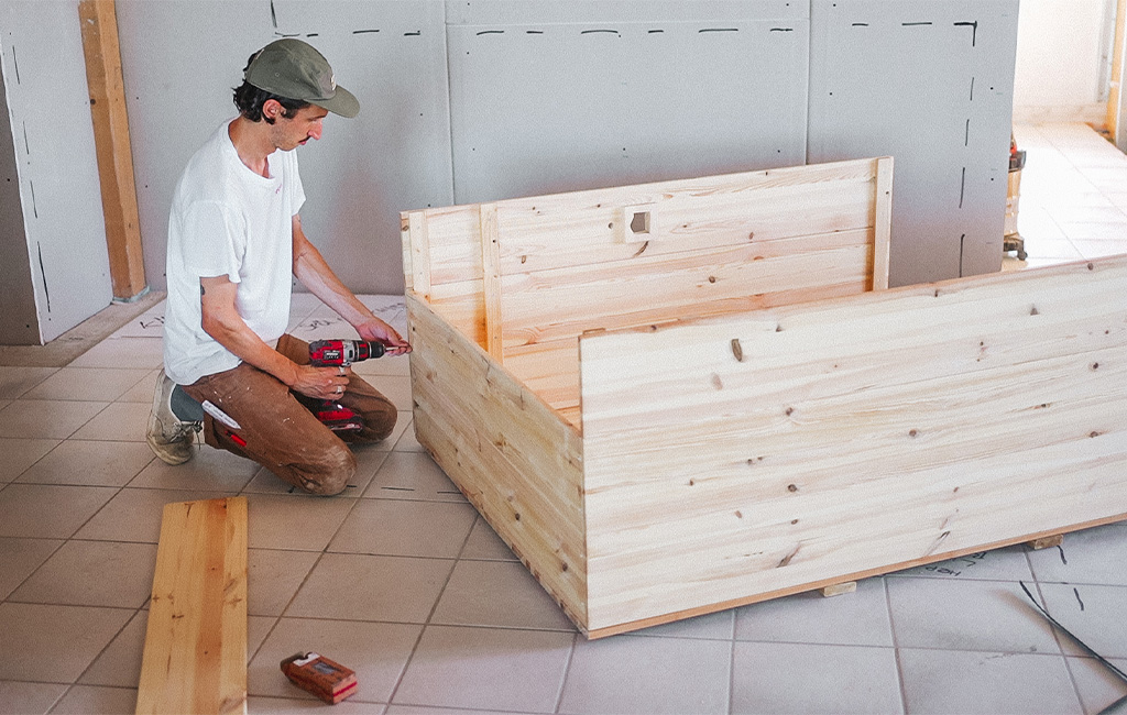 The wooden beach chair frame is assembled using a cordless drill.