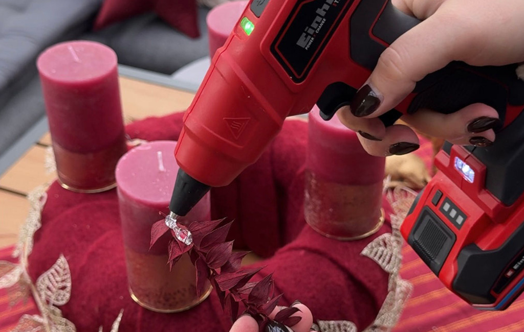 Red foliage is glued to the Advent wreath using the Einhell cordless hot glue gun TE-CG 18 Li.
