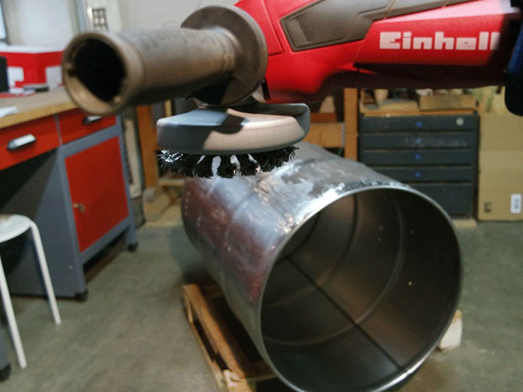 An Einhell angle grinder grinds the barrel for the smoker with the appropriate attachment.