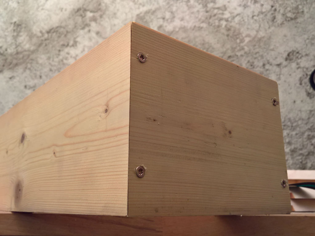 A wooden slat with screws screwed into it.
