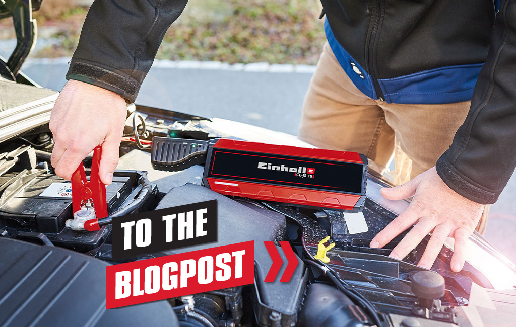 A person uses an Einhell starter to start a car
