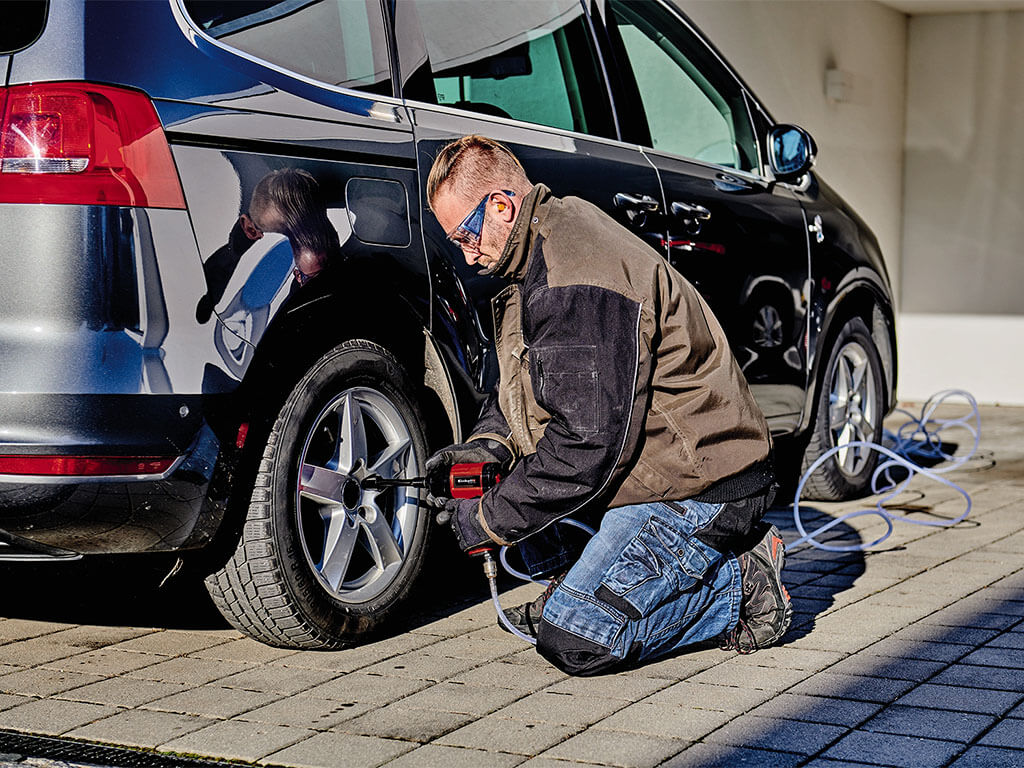 a man tightens the bolts of a car