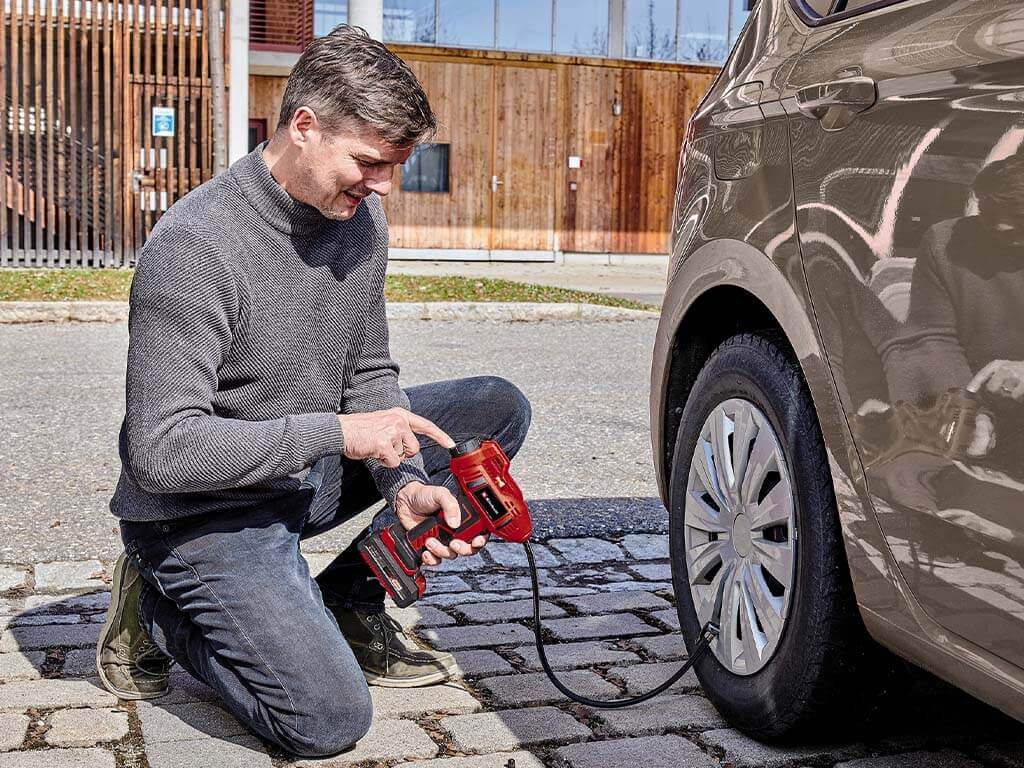 Aufpumpen von Autoreifen mit tragbarer Luftpumpe im Freien