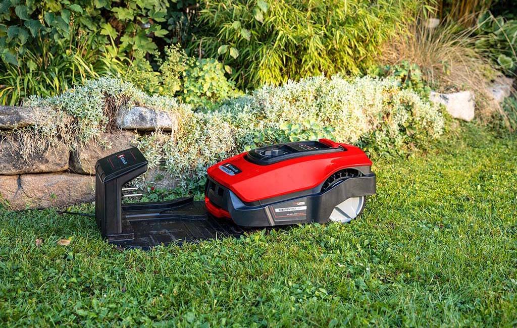 Ein Mähroboter fährt zum Aufladen in die Ladestation.