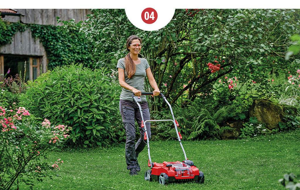 A woman working in a garden with an Einhell lawn aerator.