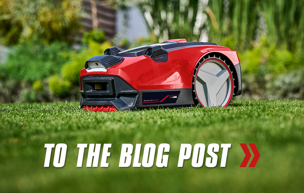 Close-up of a robot lawn mower from Einhell. Text in the foreground: To the blog post