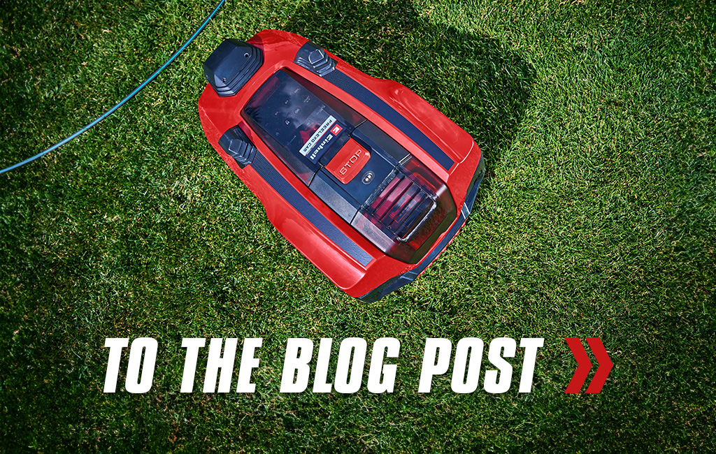 Close-up of a robot lawn mower from Einhell. Text in the foreground: To the blog post