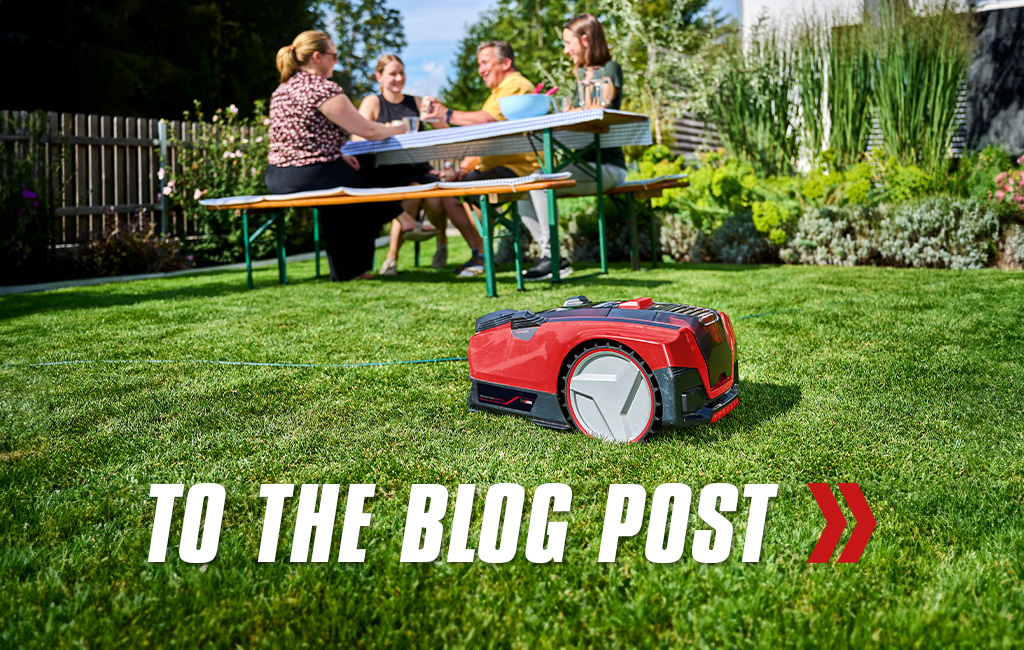 Close-up of a robot lawn mower from Einhell. Text in the foreground: To the blog post