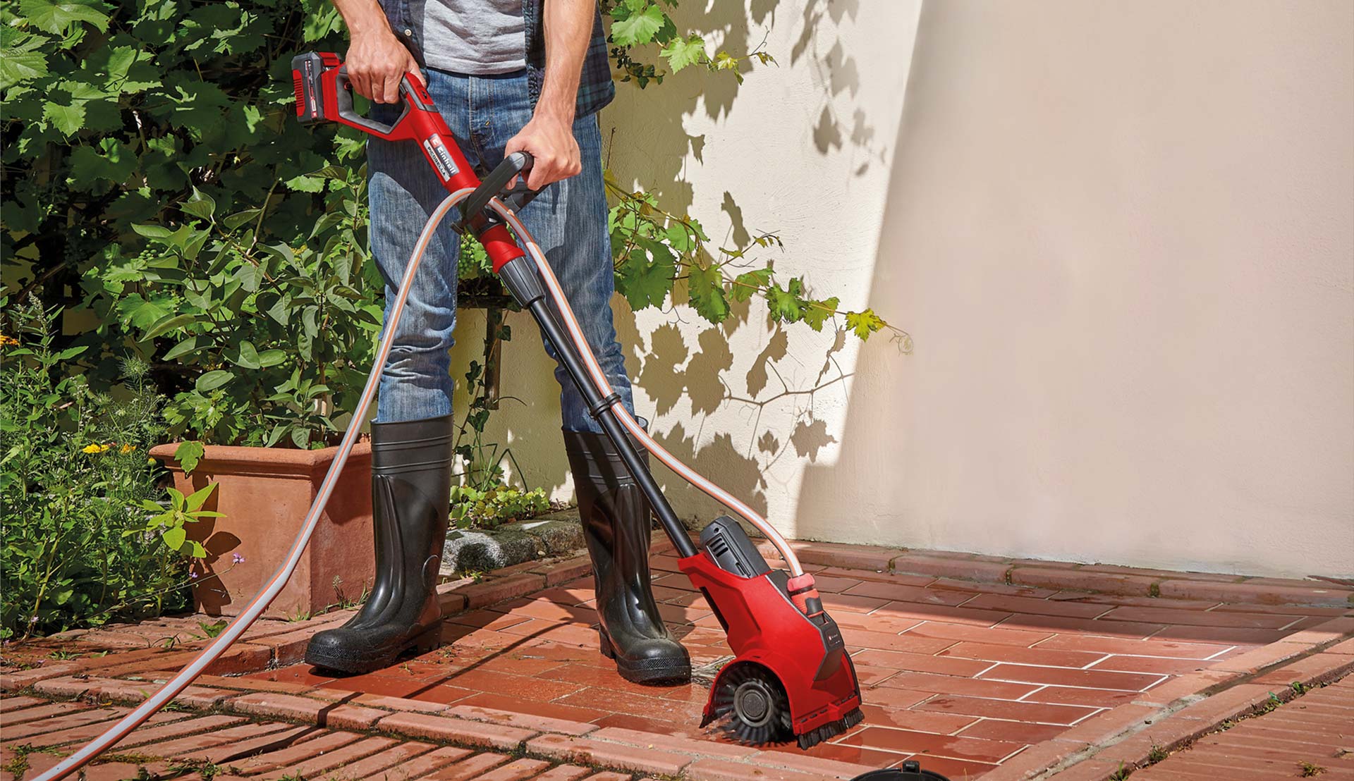 Eine Terrasse wird mit einer Einhell-Oberflächenbürste gereinigt