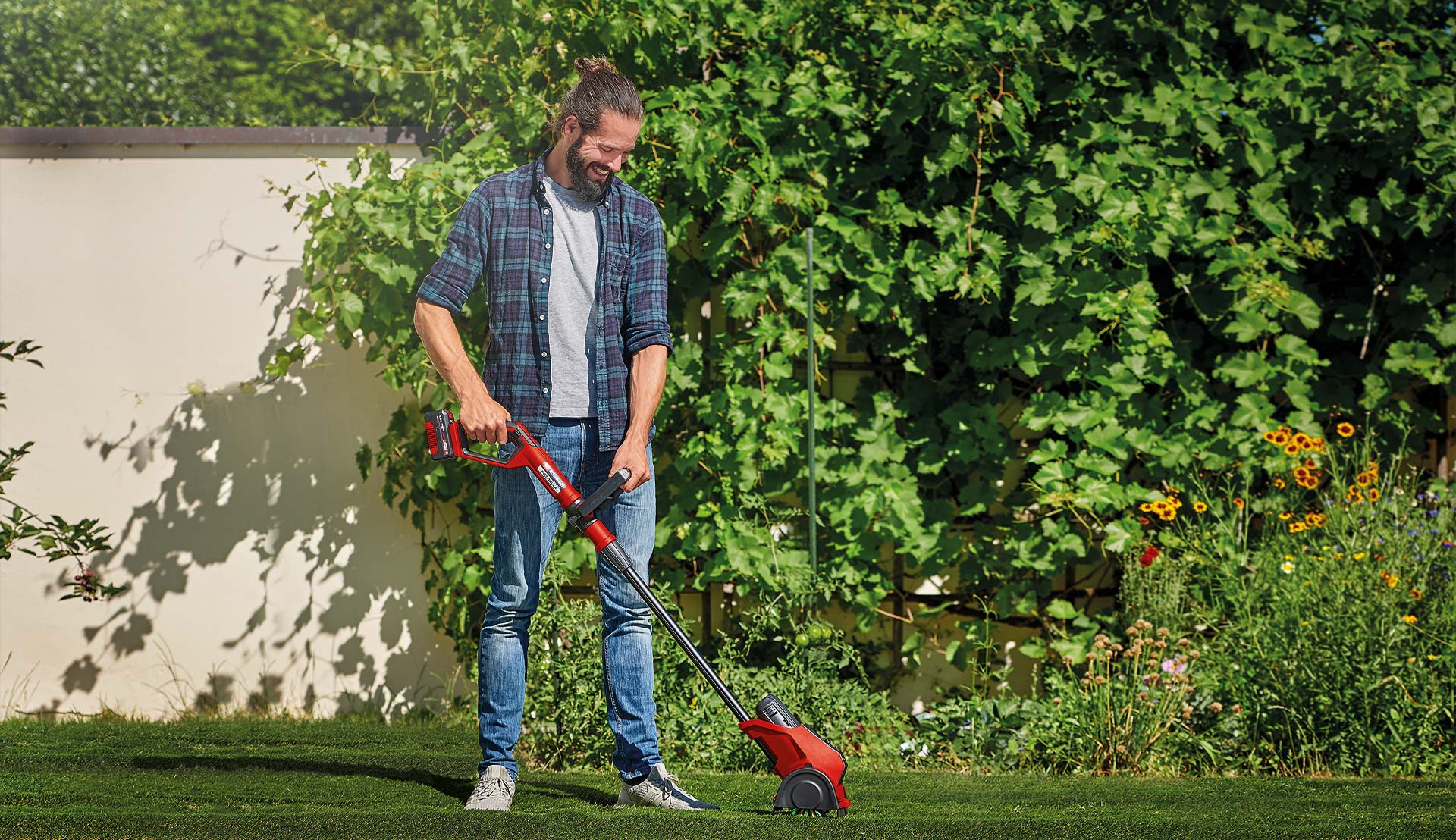 ein Mann arbeitet im Garten mit der Flächenbürste