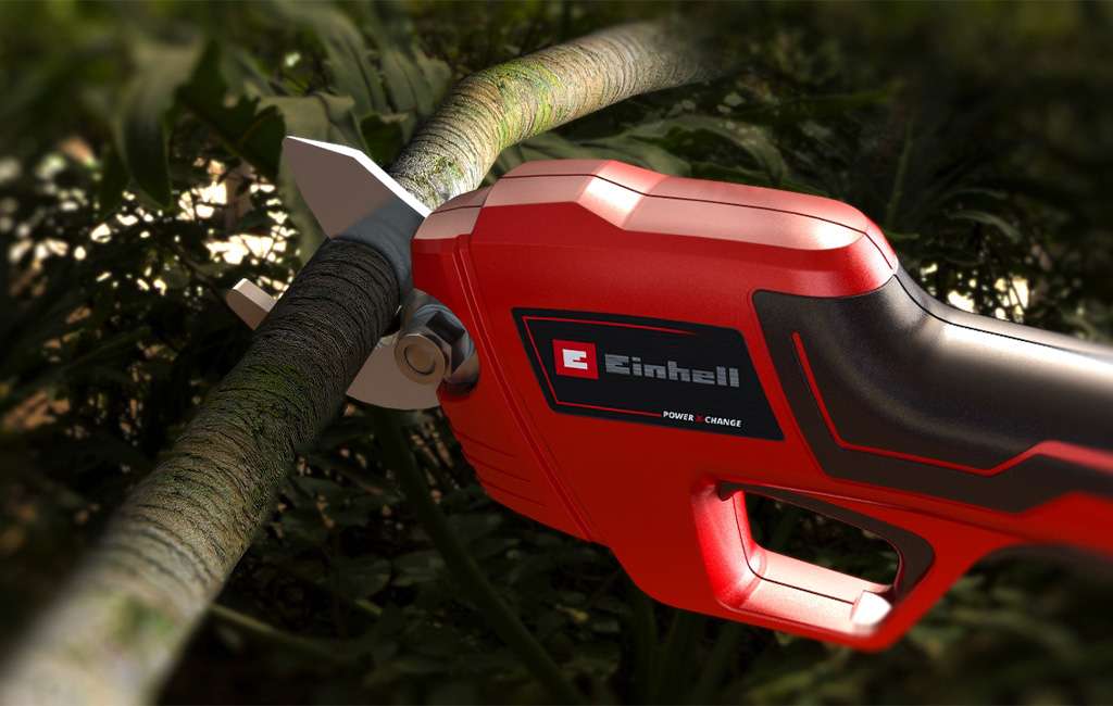 Close-up of cordless pruning shears cutting through a branch.
