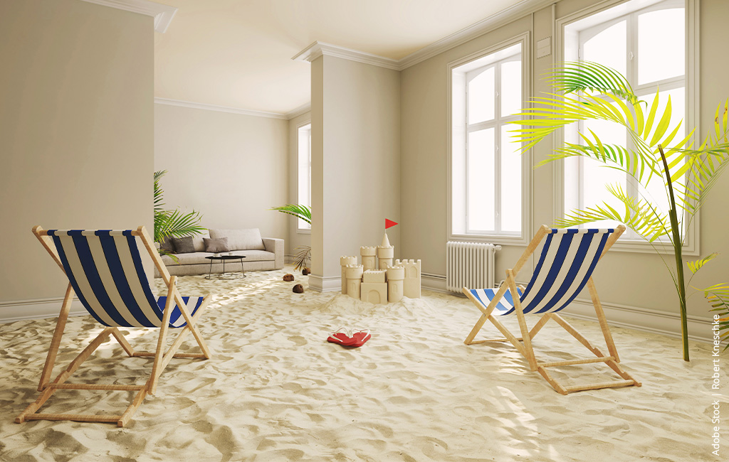 Strandliegen stehen in einem Wohnzimmer voller Sand