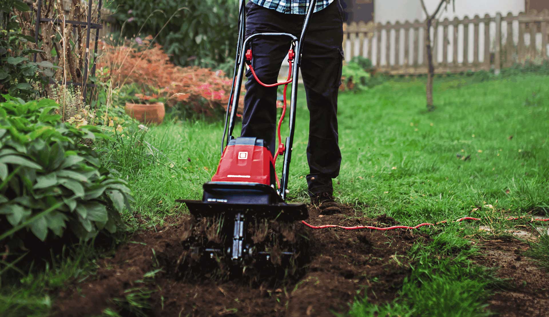Someone is using an Einhell tiller to loosen the soil
