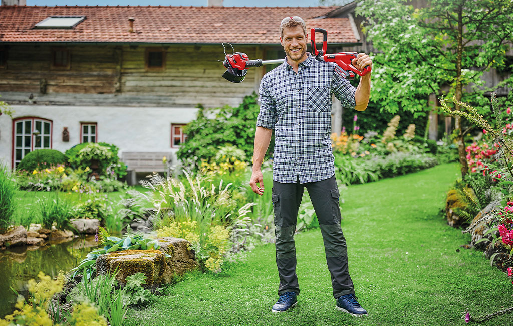 a ma is holding a Einhell cordless lawn trimmer