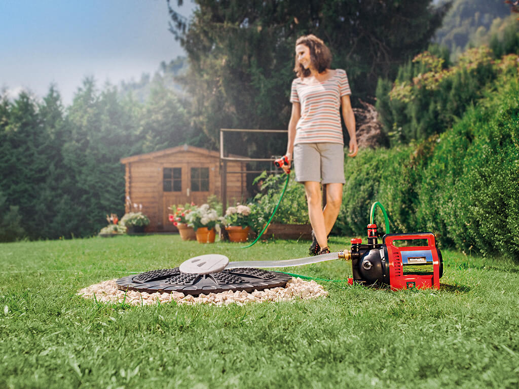 a woman waters her garden