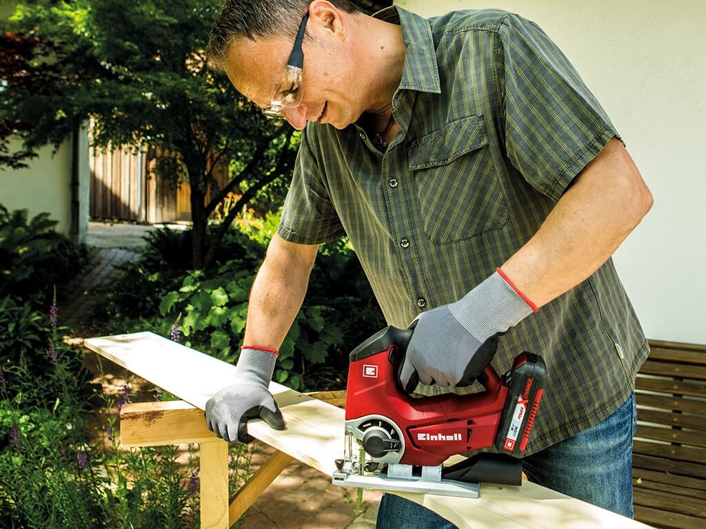 a man saws a board with a jigsaw