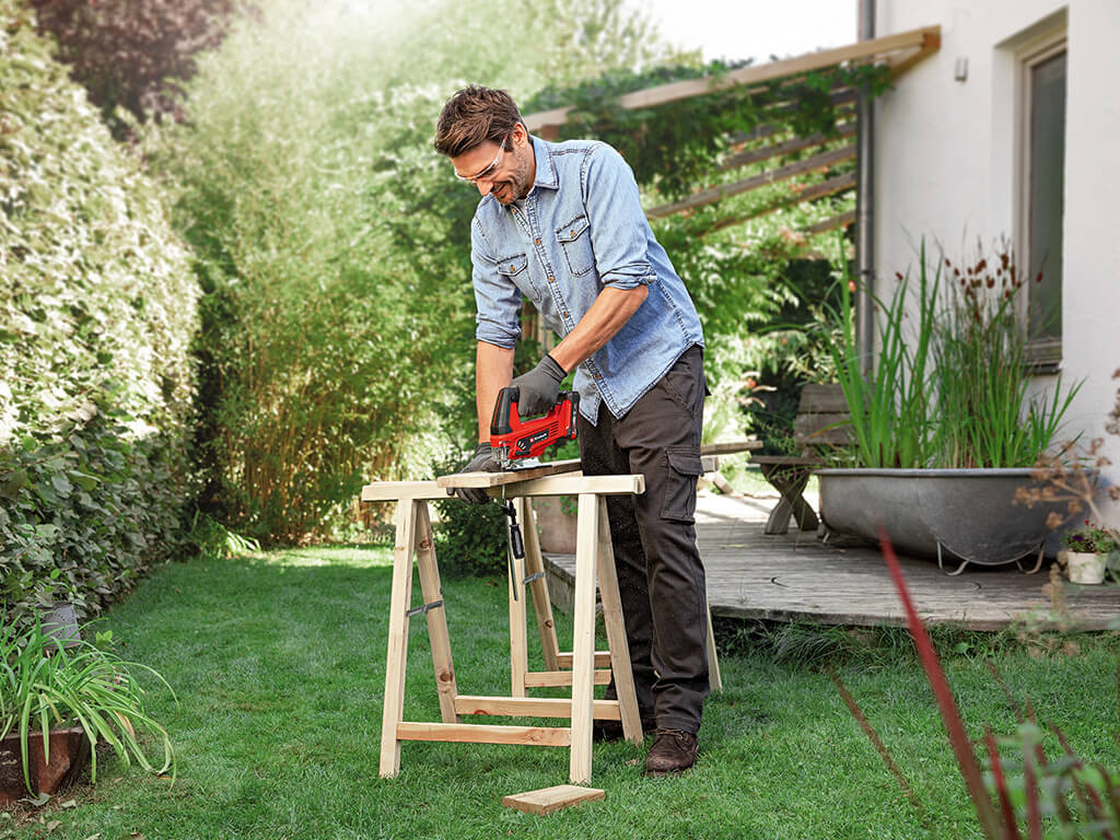 a man cuts the wood with a jigsaw