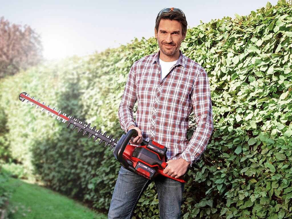 a man with a hedge trimmer in his hand