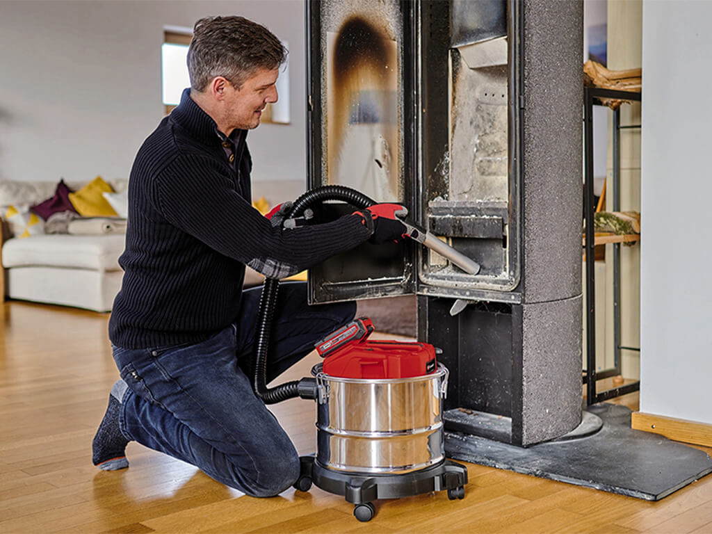 A man sucks the ashes out of his oven