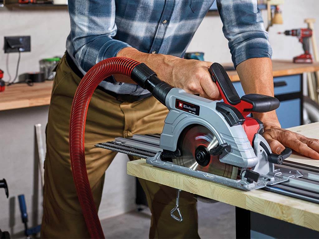 a man cuts wood with a hand circular saw