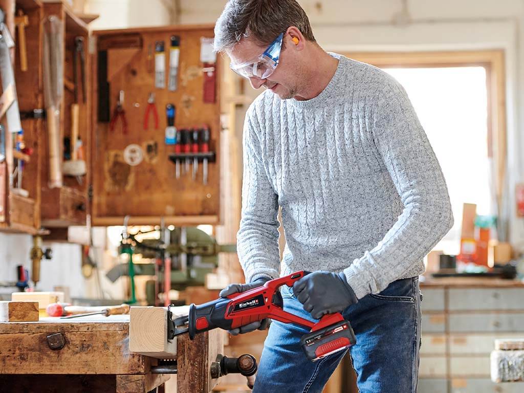 a man cuts a piece of wood 