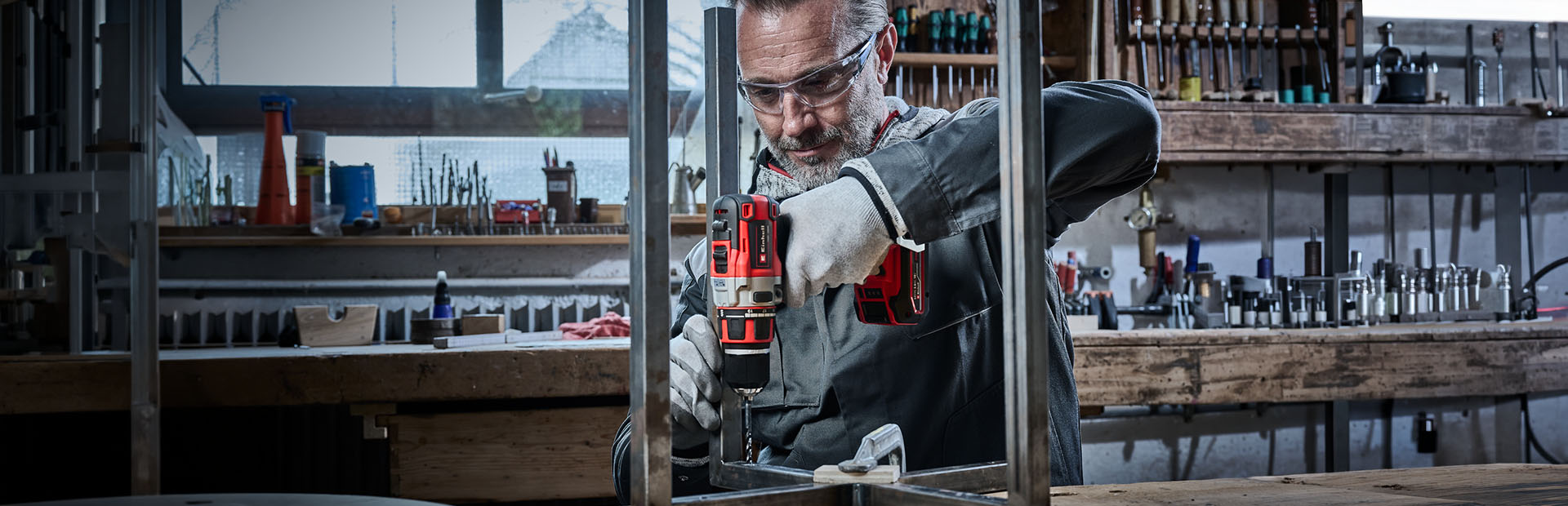 Handwerker bohrt mit einer Einhell Bohrmaschine ein Loch in ein Metallprofil.