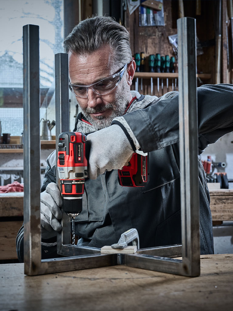 Handwerker bohrt mit einer Einhell Bohrmaschine ein Loch in ein Metallprofil.