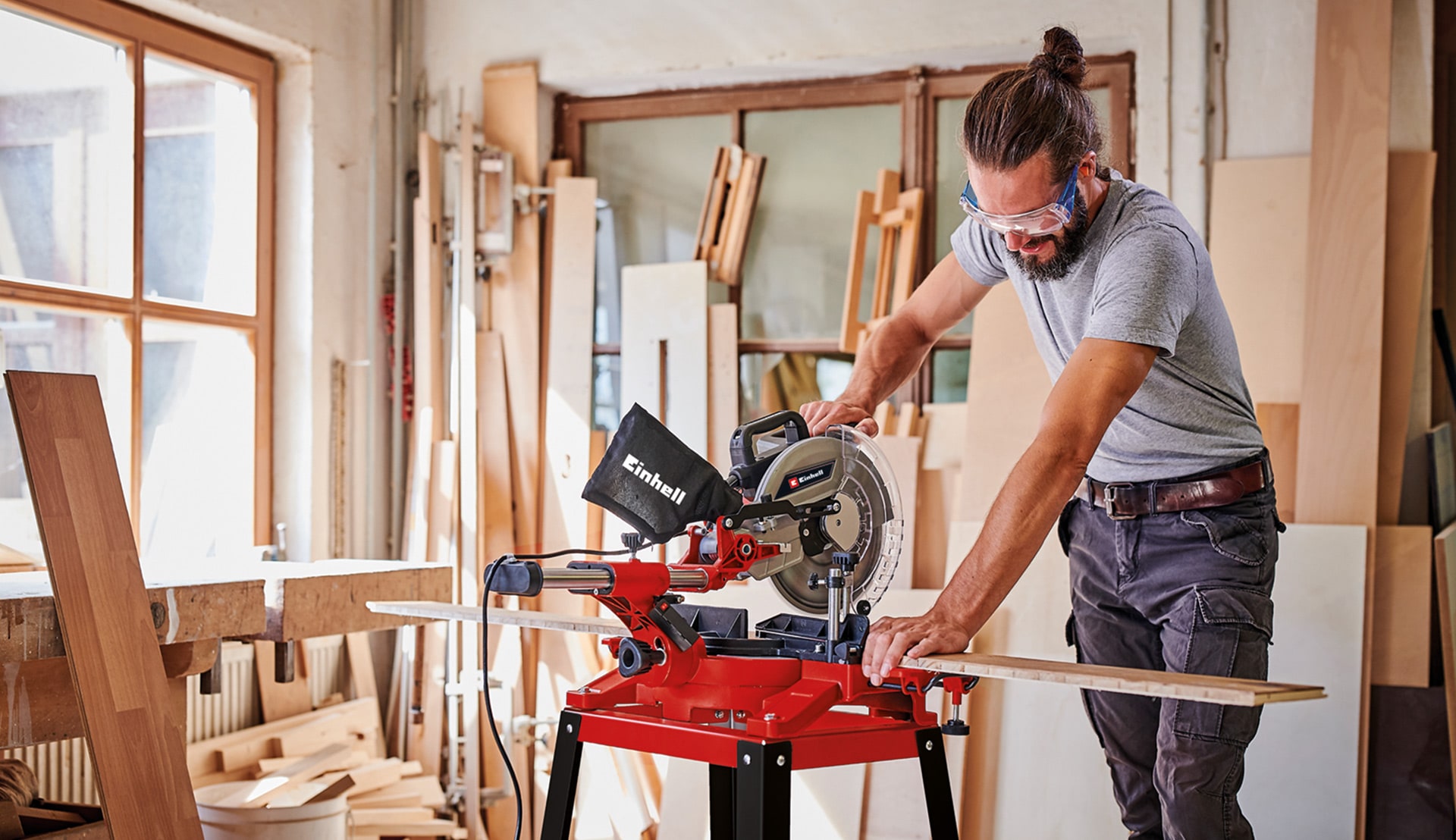 a man using a Einhell mitre saw in his workshop