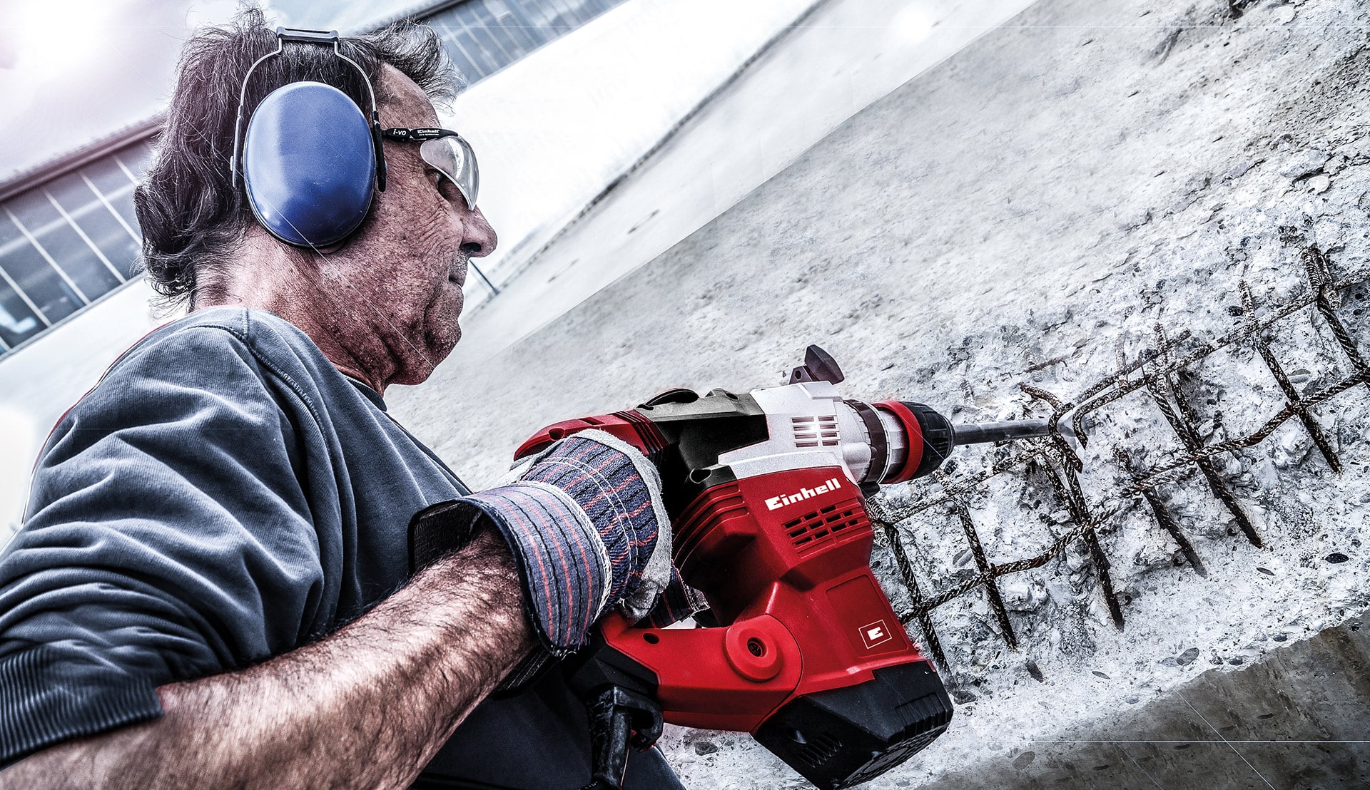 man drills away iron grille on stone