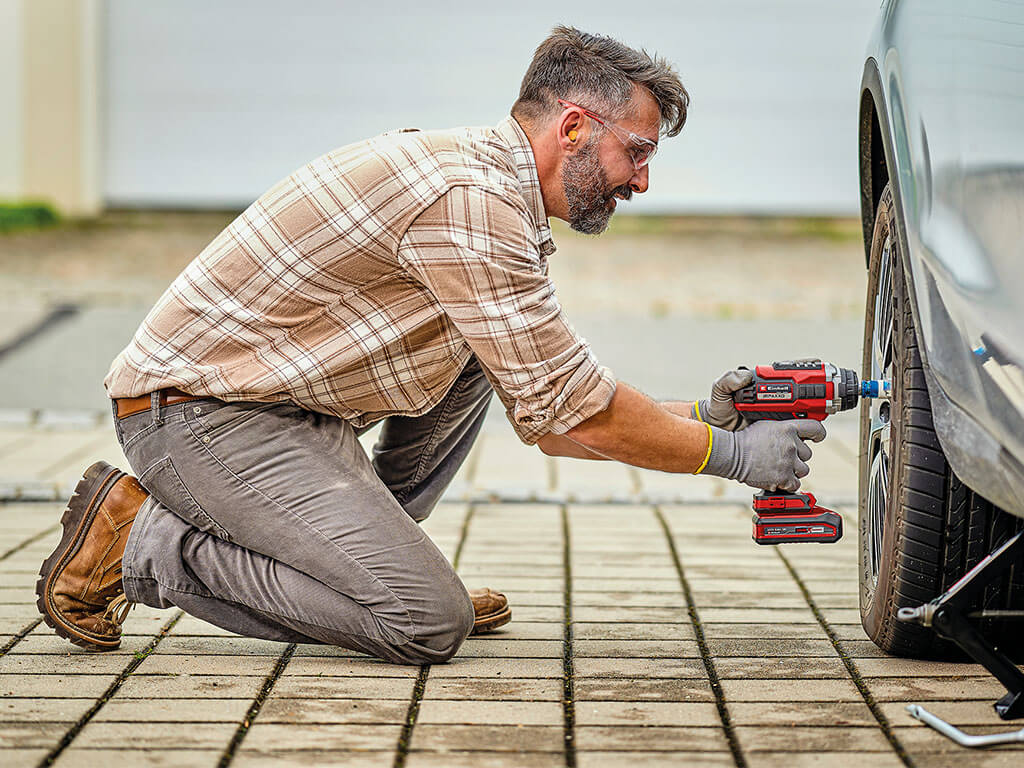 man screws screws on tire loose