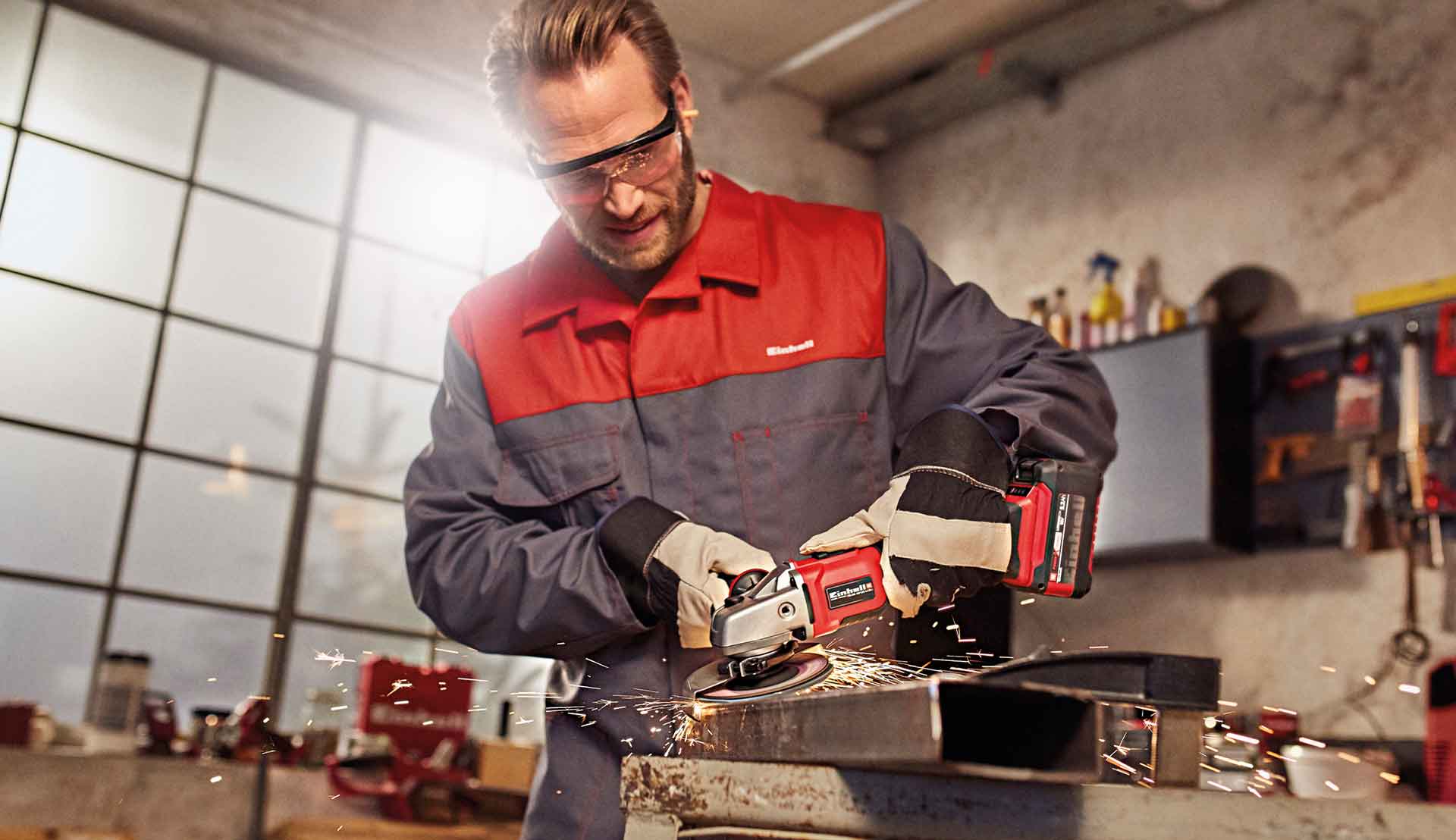 ein Mann arbeitet mit einem Einhell Winkelschleifer in einer Werkstatt