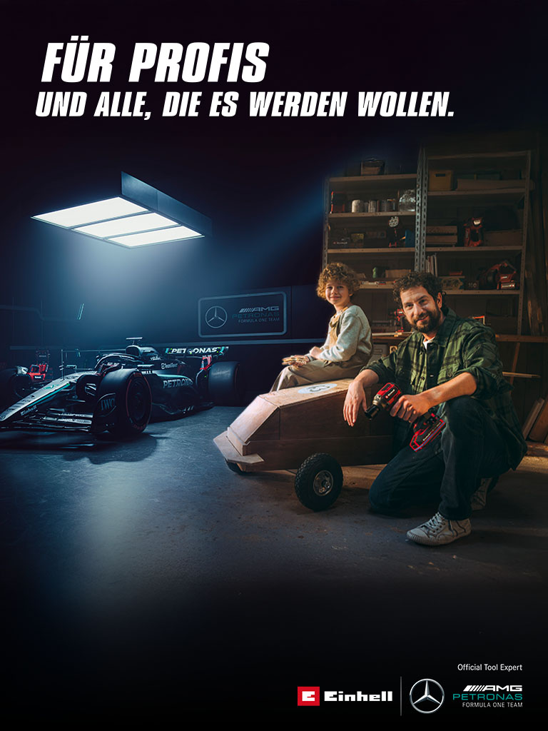 Ein Vater und sein Kind sitzen in einer Werkstatt vor einem selbstgebauten Seifenkistenauto. Im Hintergrund steht ein Mercedes-AMG PETRONAS Formel-1-Wagen mit Einhell-Werkzeugen daneben. Rechts der Text: „Für Profis und alle, die es werden wollen.“