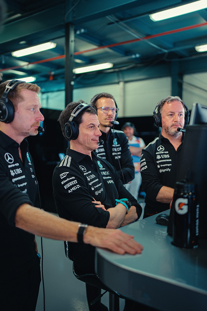 Formel-1 Teammitglieder beobachten das Rennen in der Boxengasse.