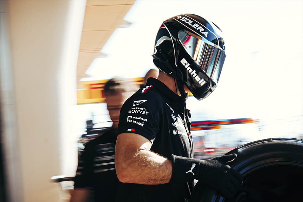 Formula 1 Mercedes mechanic carrying a tyre.