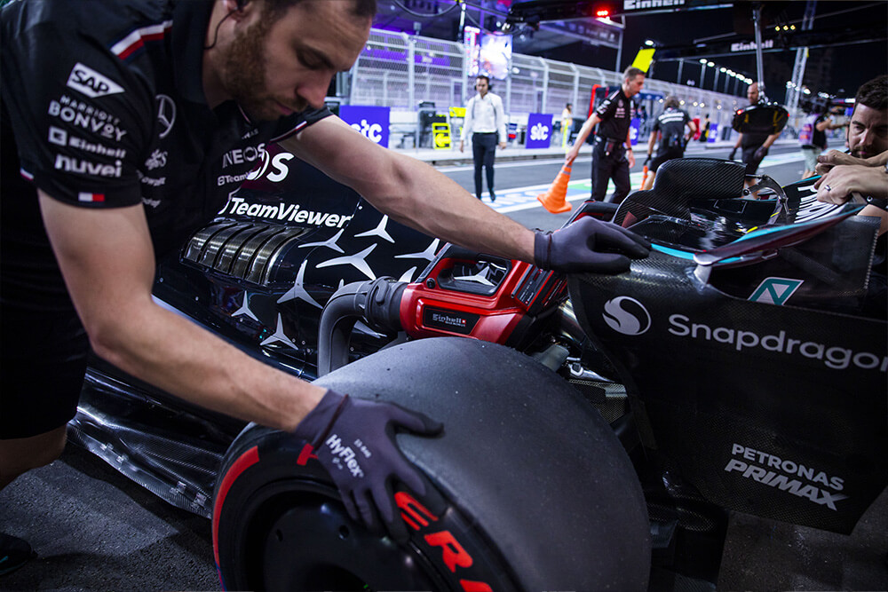 Mechanic pushing the Formula 1 Mercedes race car.