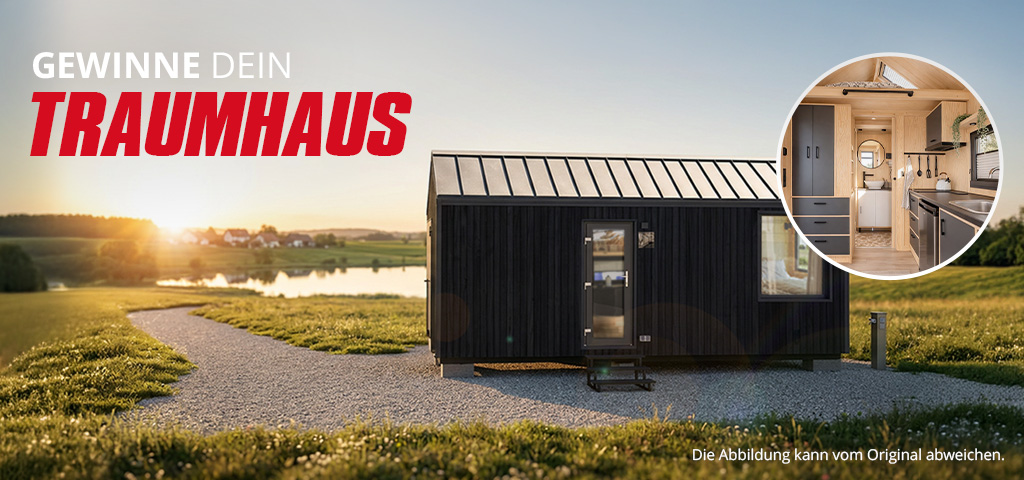 Werbebanner mit dem Text „GEWINNE DEIN TRAUMHAUS“, das ein schwarzes Tiny House in einer Wiesenlandschaft bei Sonnenuntergang zeigt.