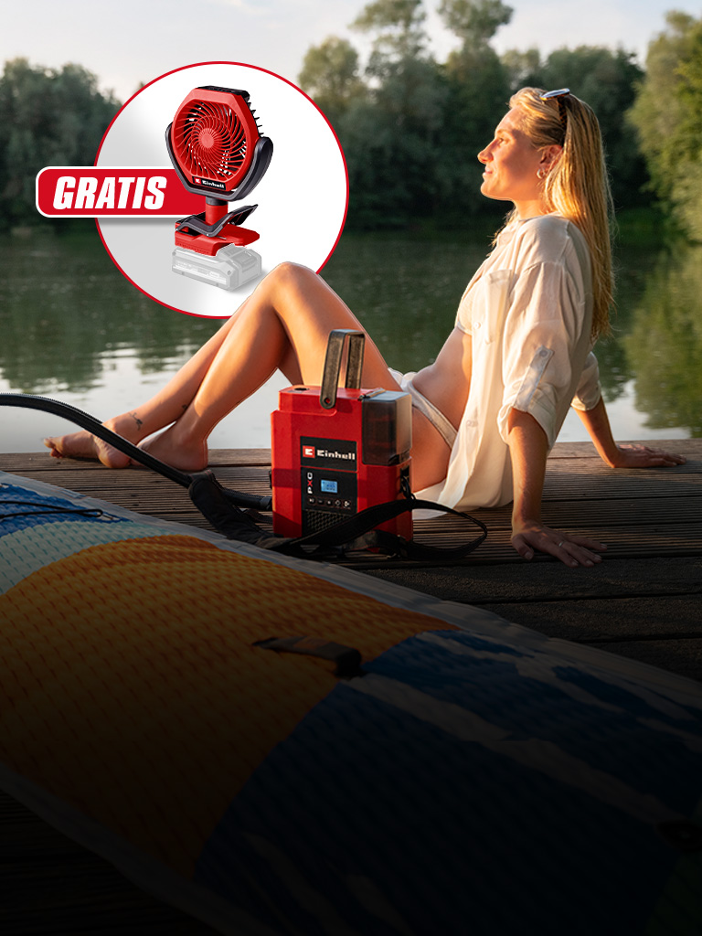 Frau sitzt am See auf Steg, rotes Einhell Gerät pumpt SUP auf, Einblendung mit Ventilator und Text „GRATIS“.