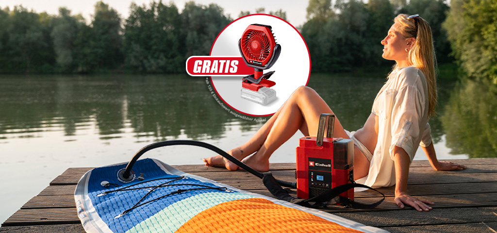 Frau sitzt am See auf Steg, rotes Einhell Gerät pumpt SUP auf, Einblendung mit Ventilator und Text „GRATIS“.