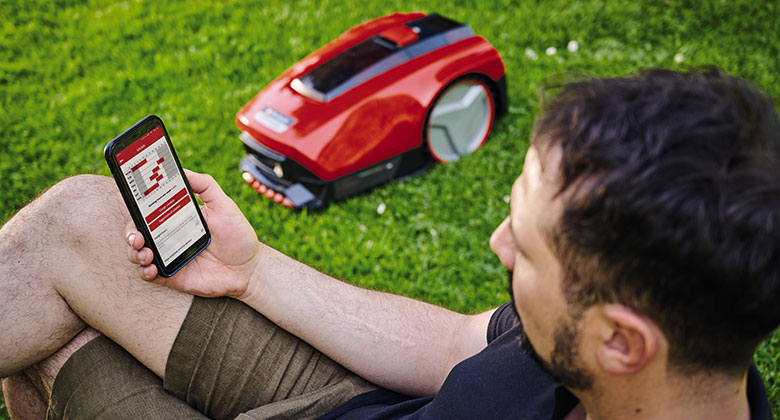 ein Mann nutzt die Einhell Connect App zur Steuerung eines FREELEXOs